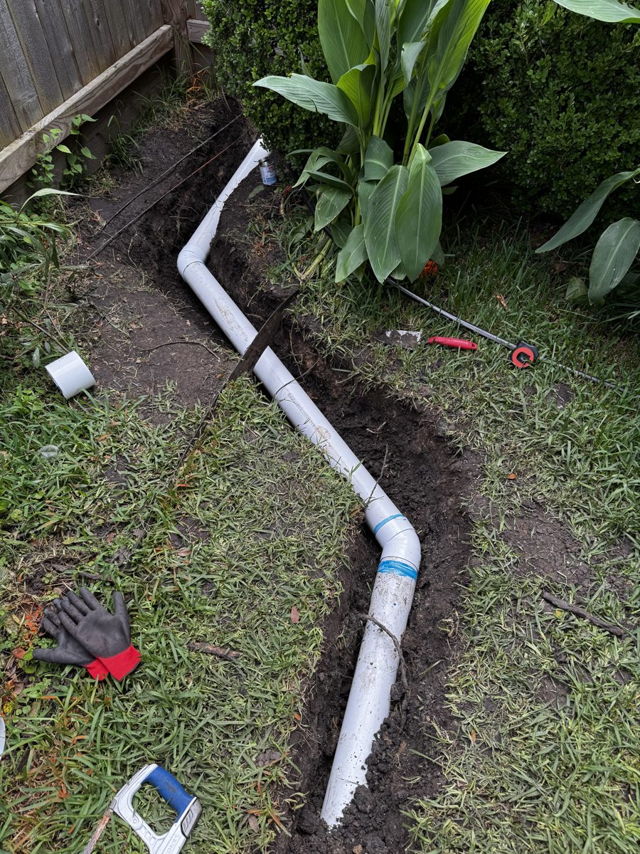 Finished French drain backfilled with gravel and drain grate