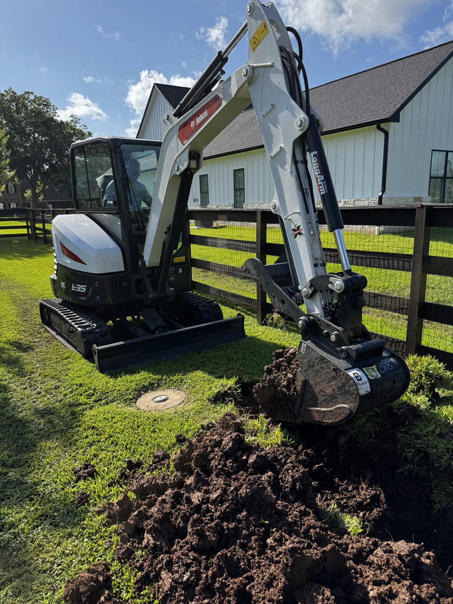Mini excavator digging a drainage trench — Richmond, TX